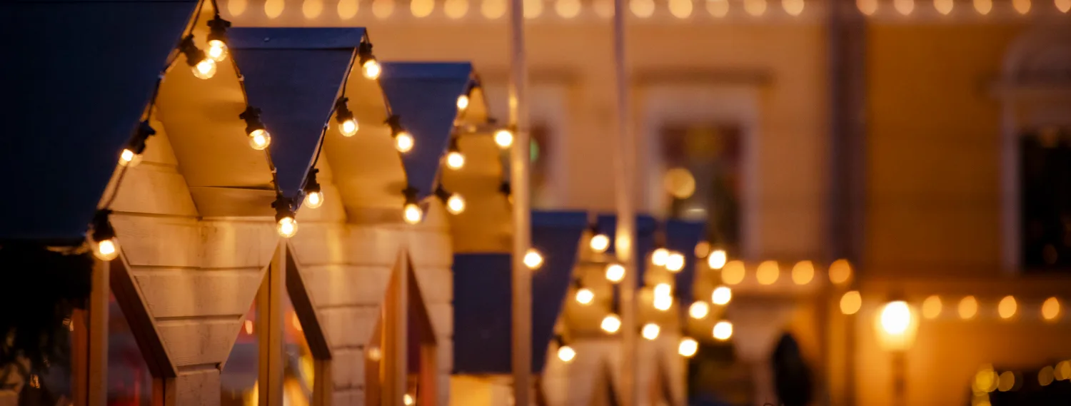 Joulutorilla tai joulumarkkinoilla olevia mökkejä valoineen.