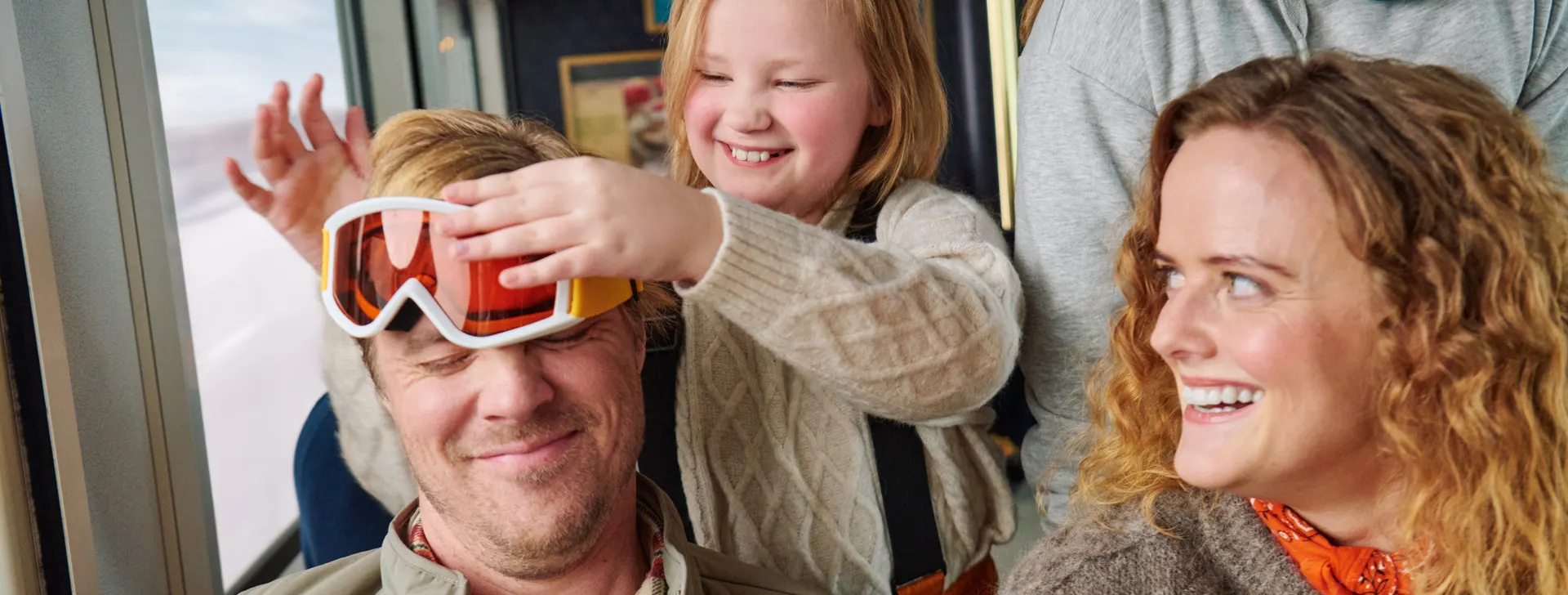 En familj som skrattar och busar i nattågets restaurangvagn.