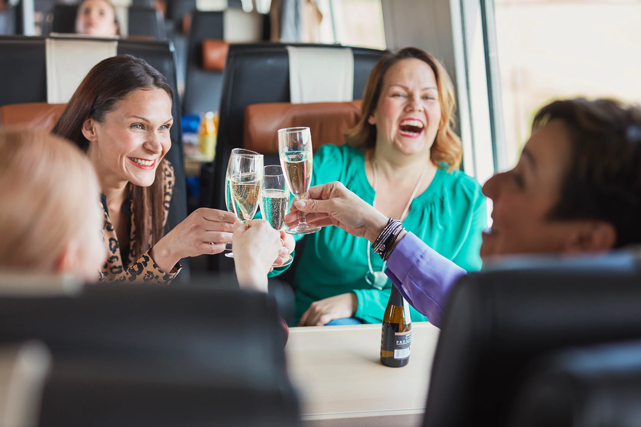 Naiset skoolaavat kuohuviinillä junan ravintolavaunun yläkerrassa