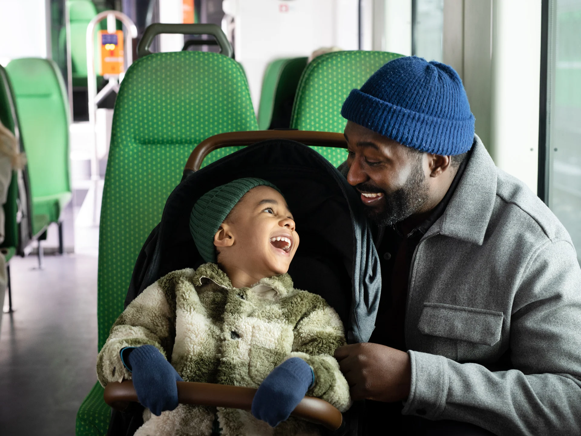 Pappa med sin son i barnvagn på ett VR-närtåg.