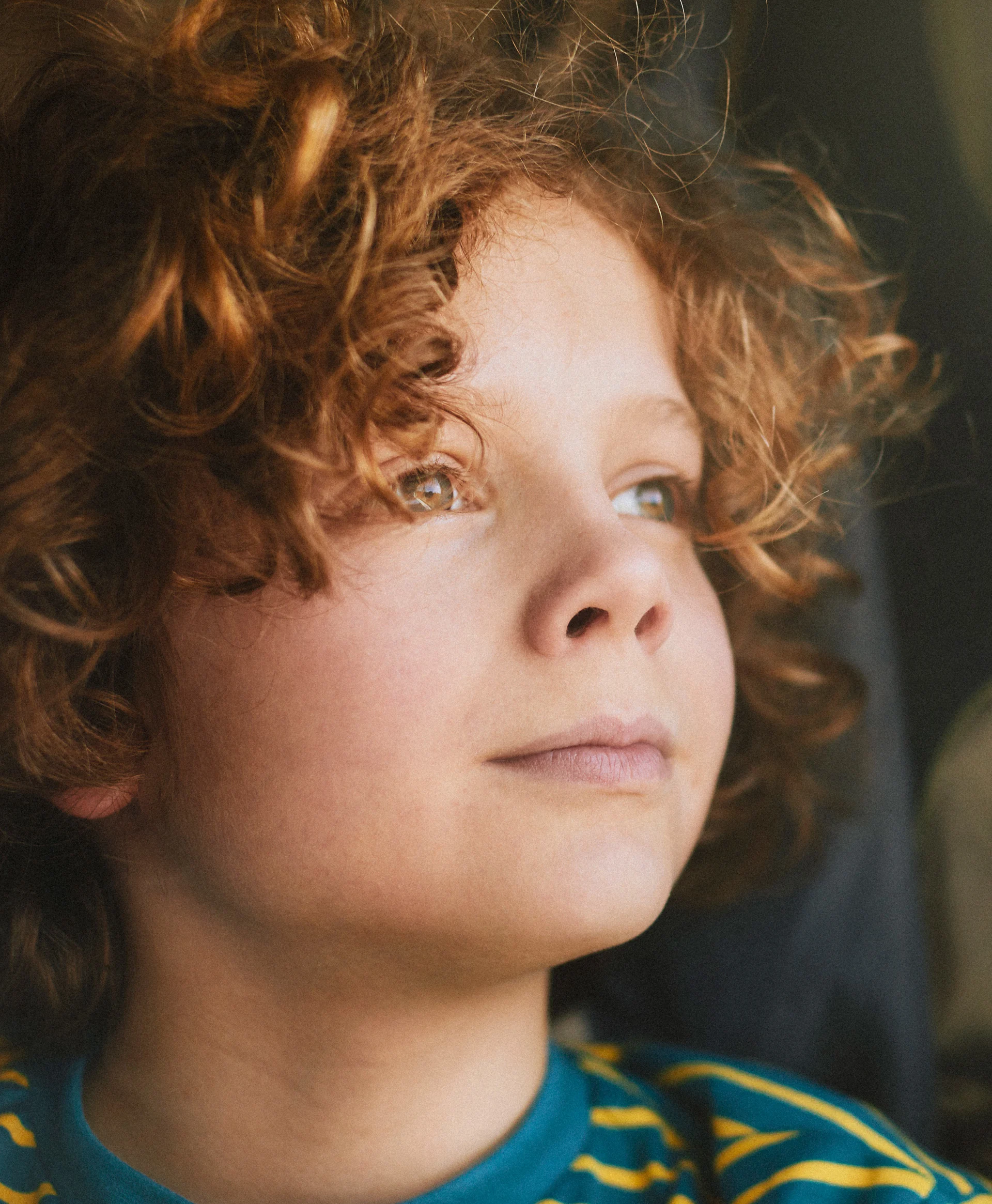 Lapsi ulkona vanhemman sylissä aurinkoisessa ja keväisessä säässä.