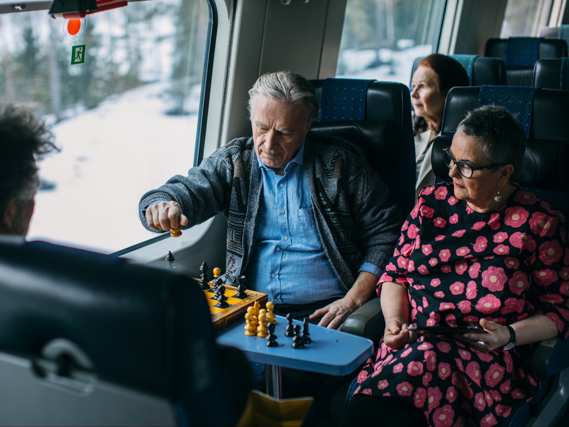 Två pensionärer spelar schack på ett fjärrtåg.
