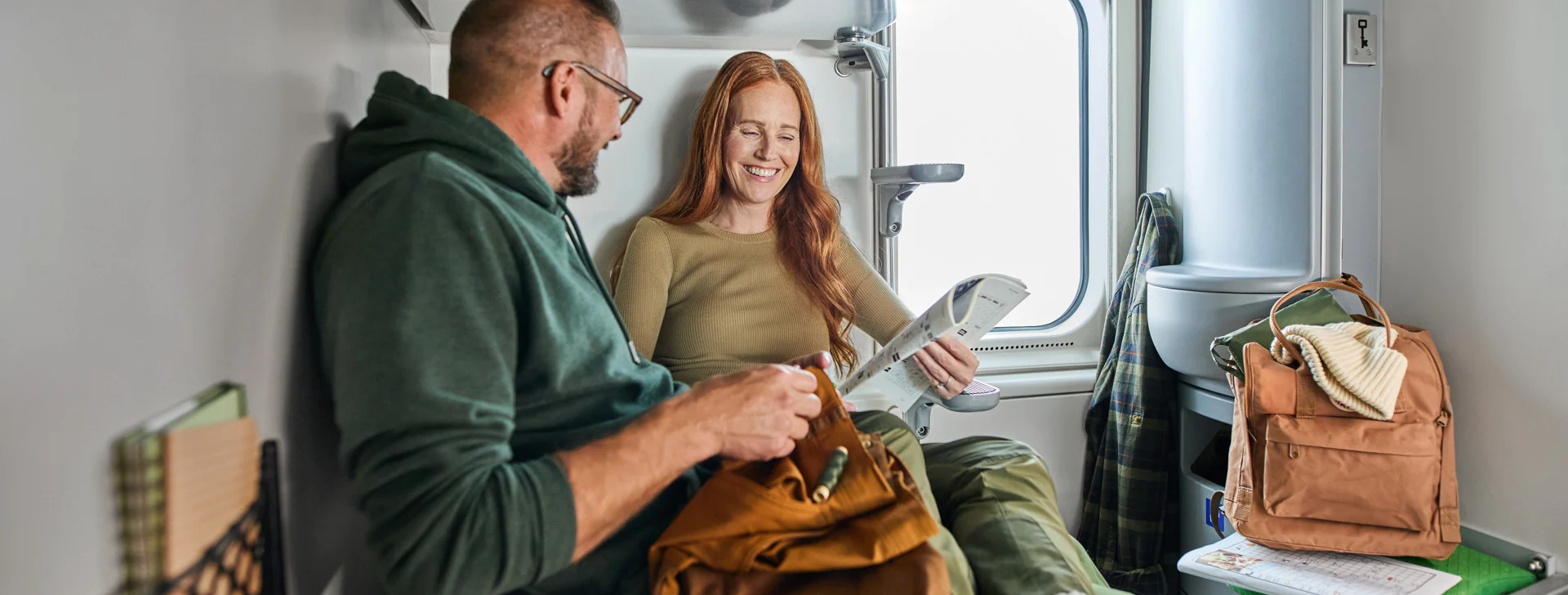 Yöjuna, jonka takana näkyy yöllinen tähtitaivas ja revontulia.