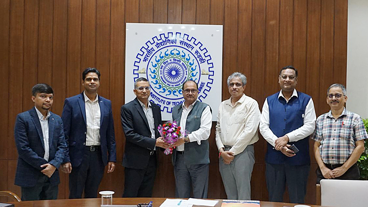 Representatives from OMRON and IIT Roorkee shaking hands and posing together around a conference table during an event to strengthen industry-academia collaboration.