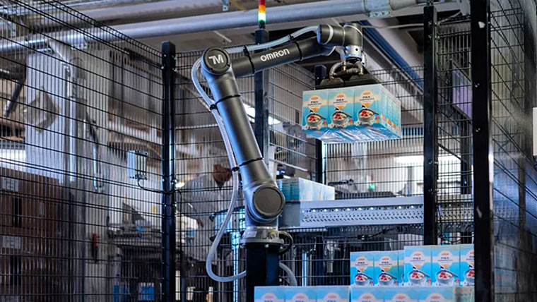 スマート工場の生産ラインで稼働するオムロンの産業用ロボットアーム