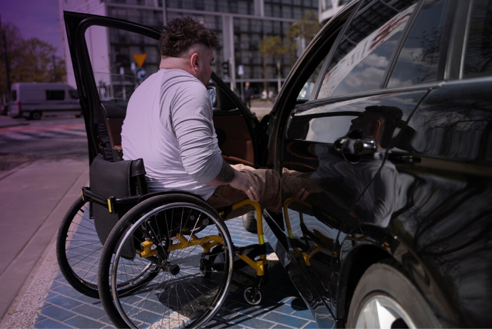 Hombre en silla de ruedas a punto de entrar a un auto.