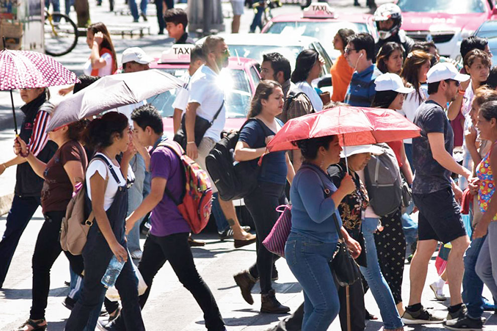 Personas cruzando una calle, algunas de ellas llevando un paraguas.