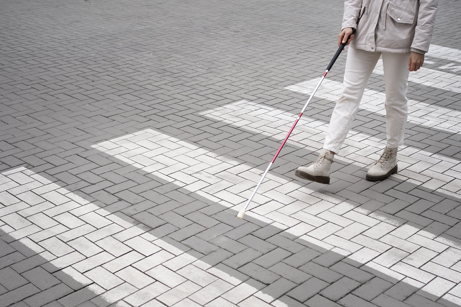 Una mujer ciega cruzando un pase de cebra