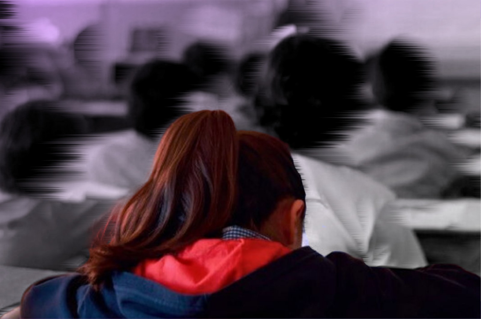 Conjunto de estudiantes en un salón de clases, todos de espalda.