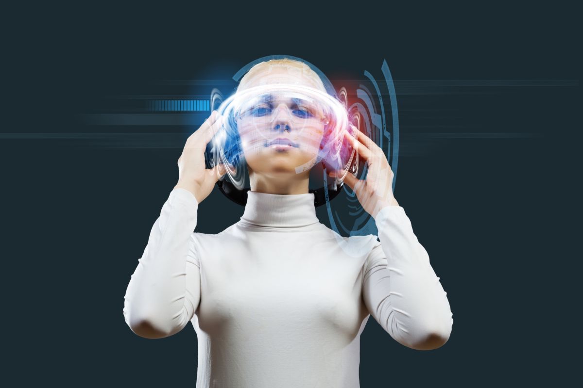 Una mujer con un casco de realidad virtual y las manos sobre sus oídos. Foto de 123RF/ra2studio

