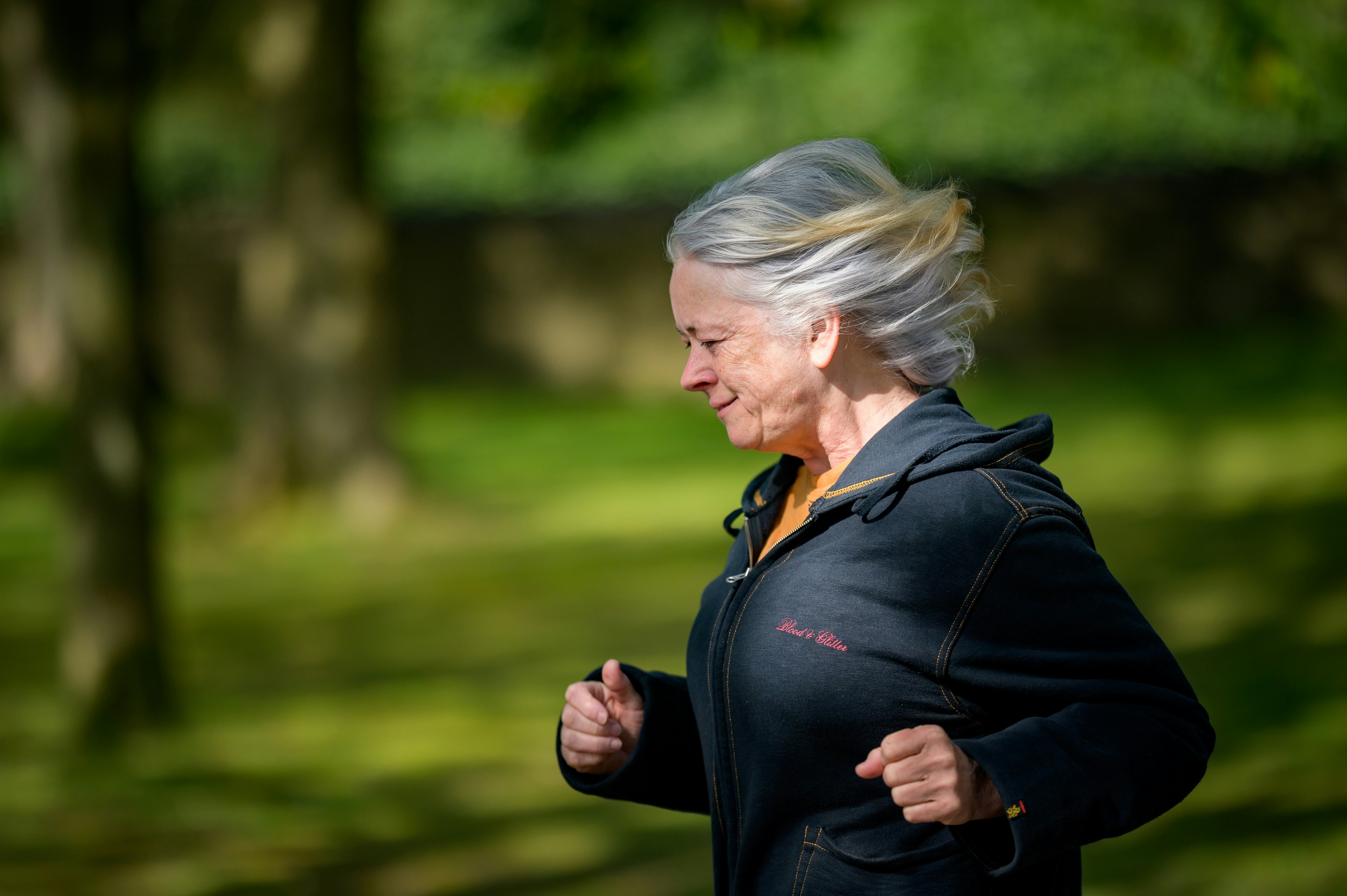 Mujer de la tercer edad corriendo en un parque.