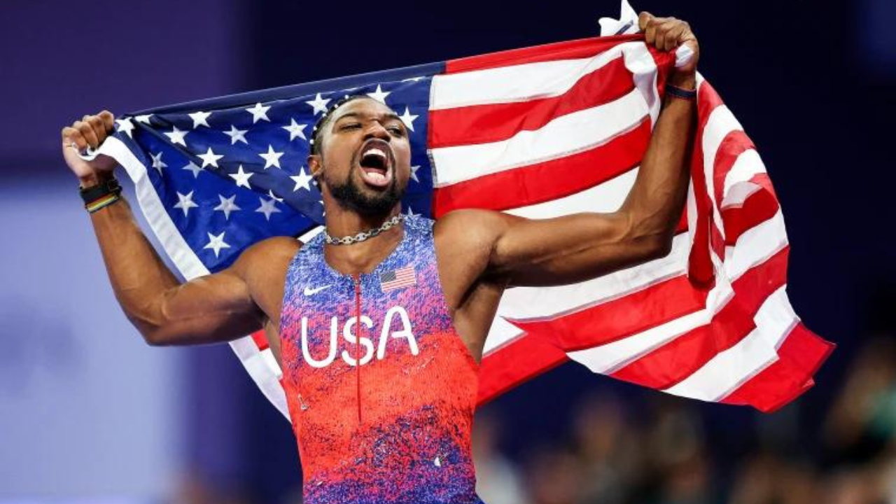 Noah Lyles con la bandera de Estados Unidos.