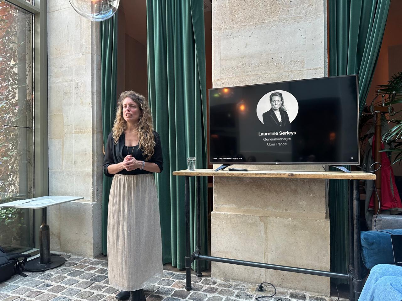 Laureline Serieys, General Manager de Uber en Francia, de pie. Detrás de ella una pantalla con una fotografía suya.