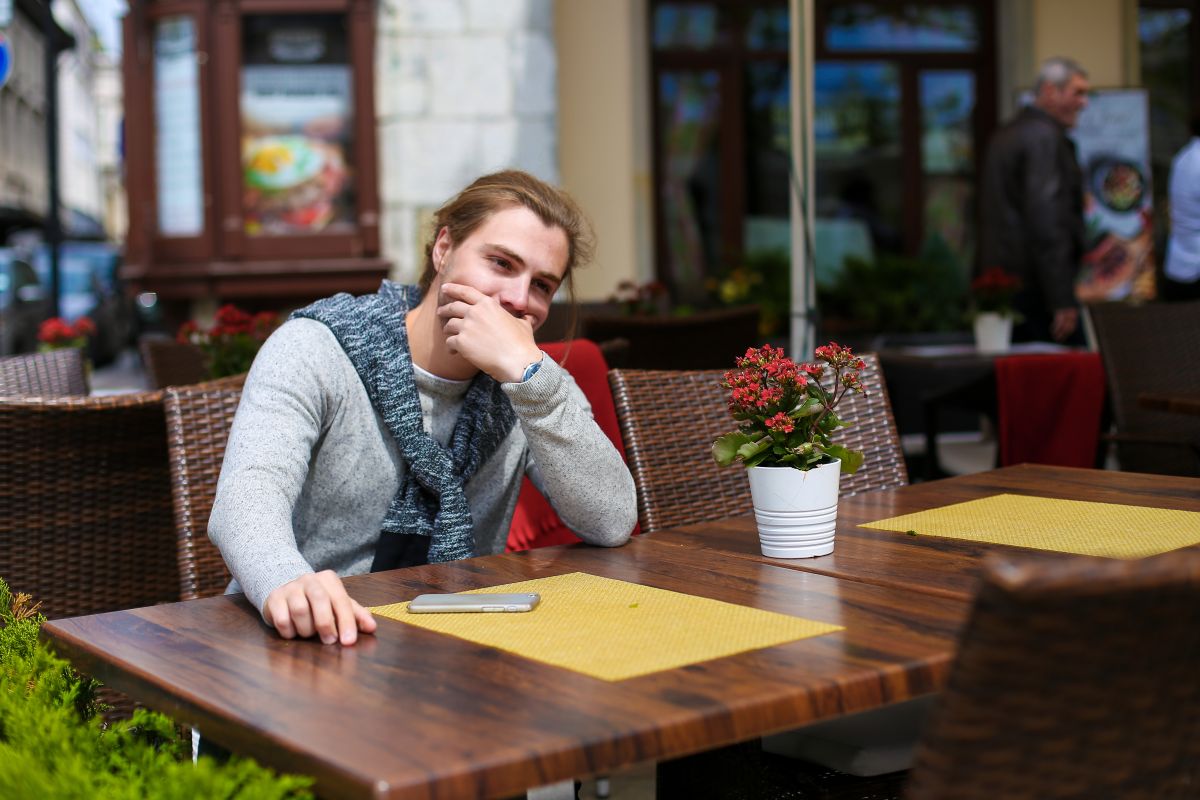 Persona con autismo sentada en la terraza de un restaurante | Foto de 123RF/sisterspro

