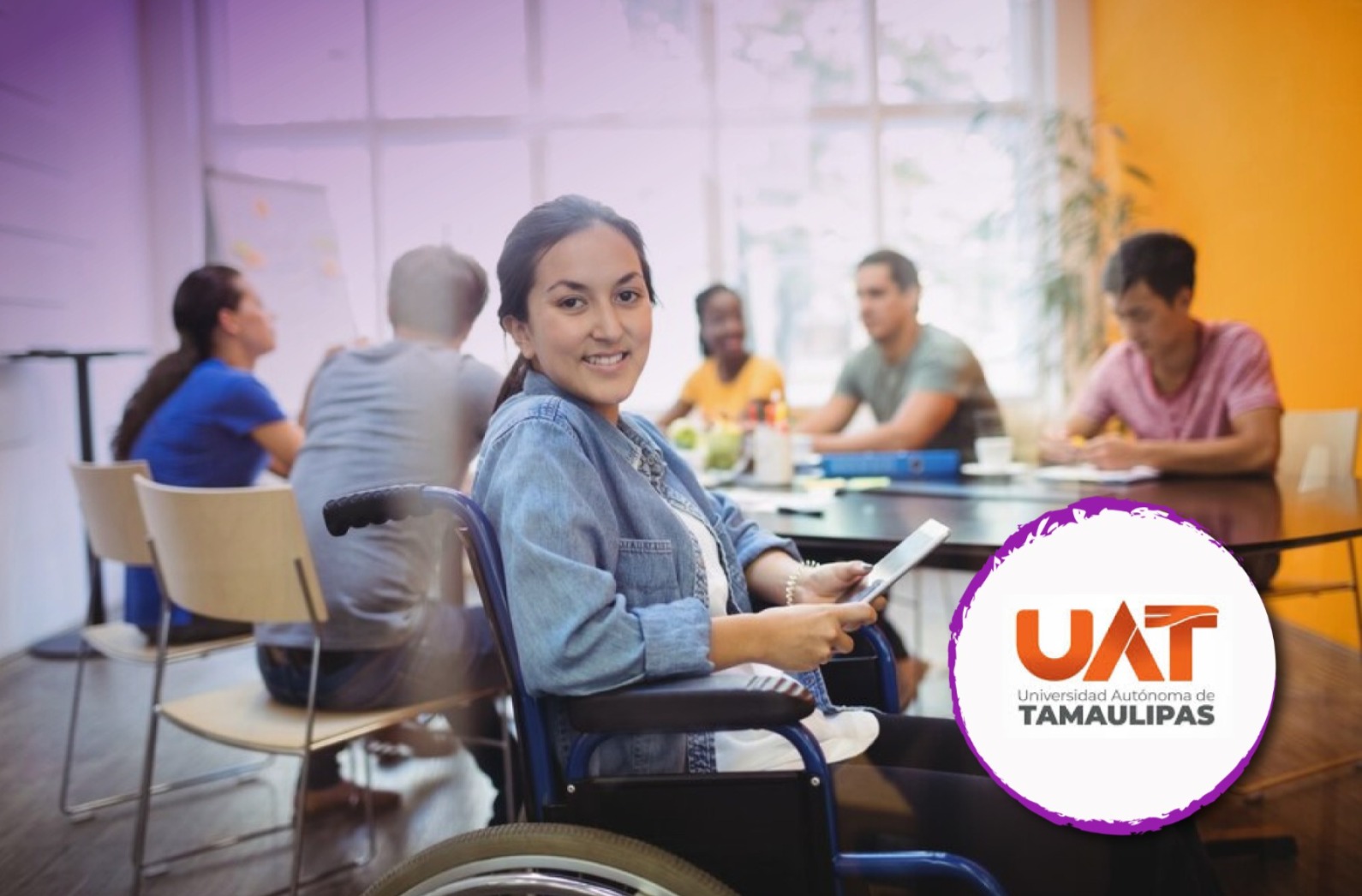 Estudiante en silla de ruedas en una mesa junto a más jóvenes.