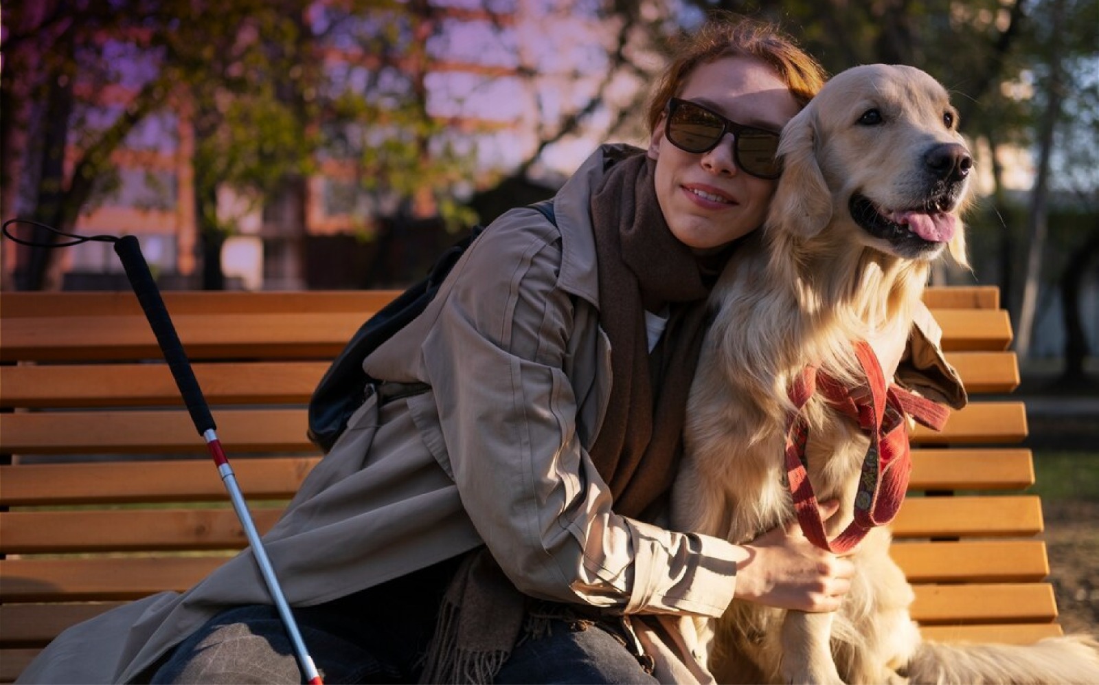 Mujer con discapacidad visual abrazando a un perro guía.