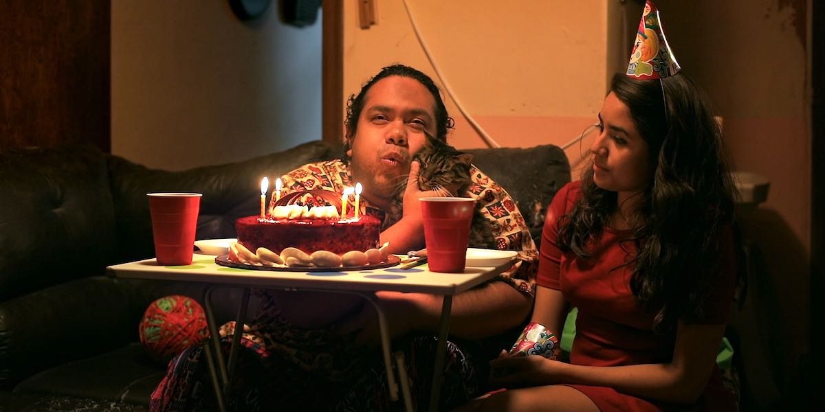 Hombre soplando una vela de un pastel de cumpleaños como parte de un fragmento del documental "Iluminados".