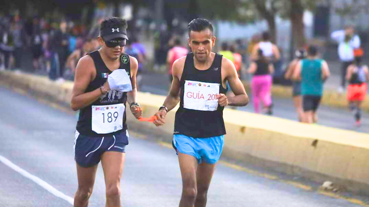 Dos maratonistas, uno de ellos con discapacidad visual, en el medio maratón de Guadalajara.