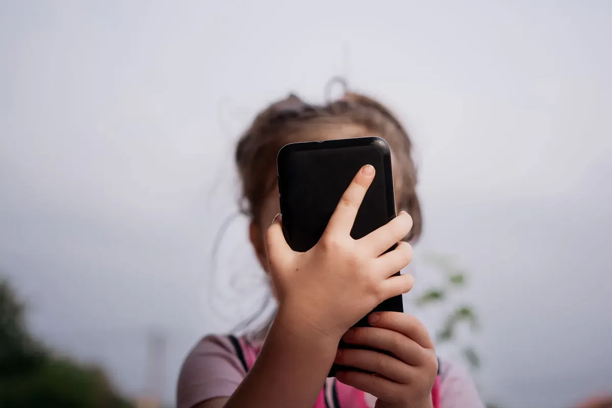 Niña usando un teléfono celular.