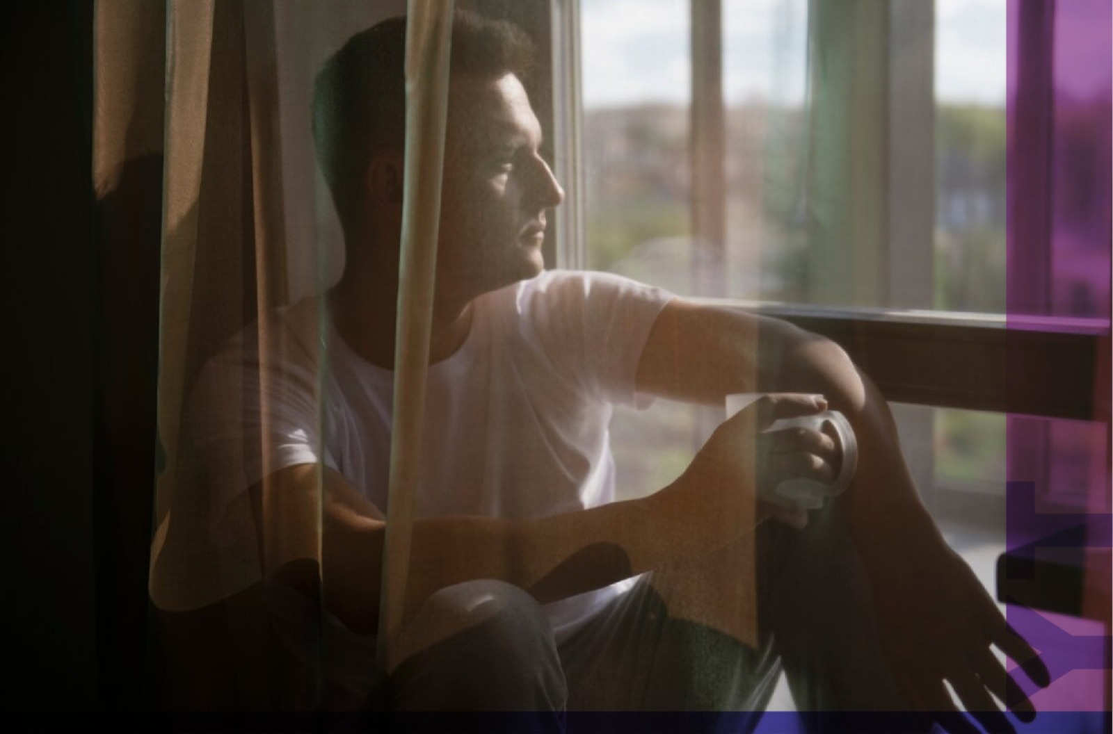 Fotografía de un hombre mirando a través de una ventana.