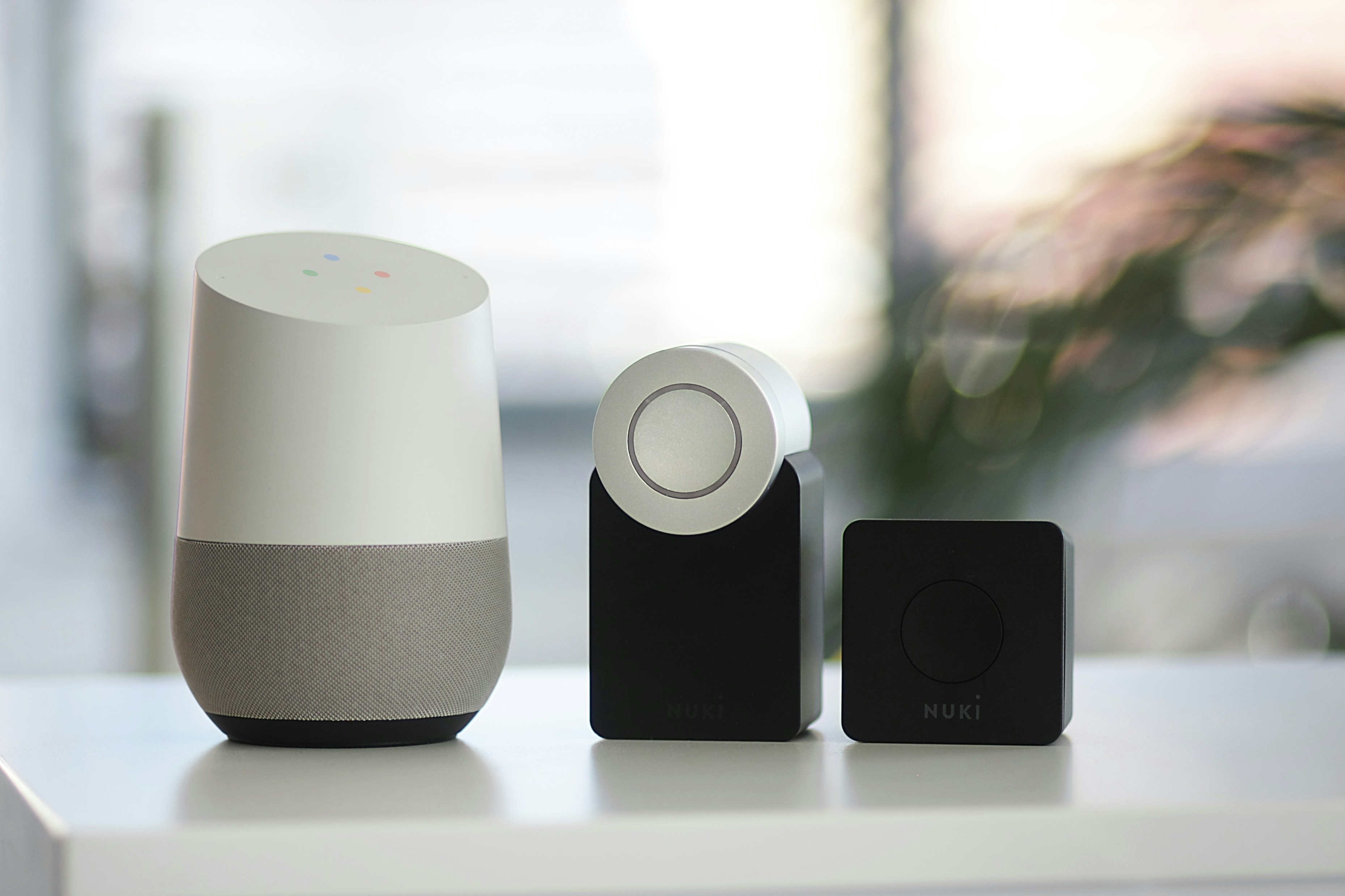 Altavoz inteligente Google blanco con gris y dos altavoces negros.