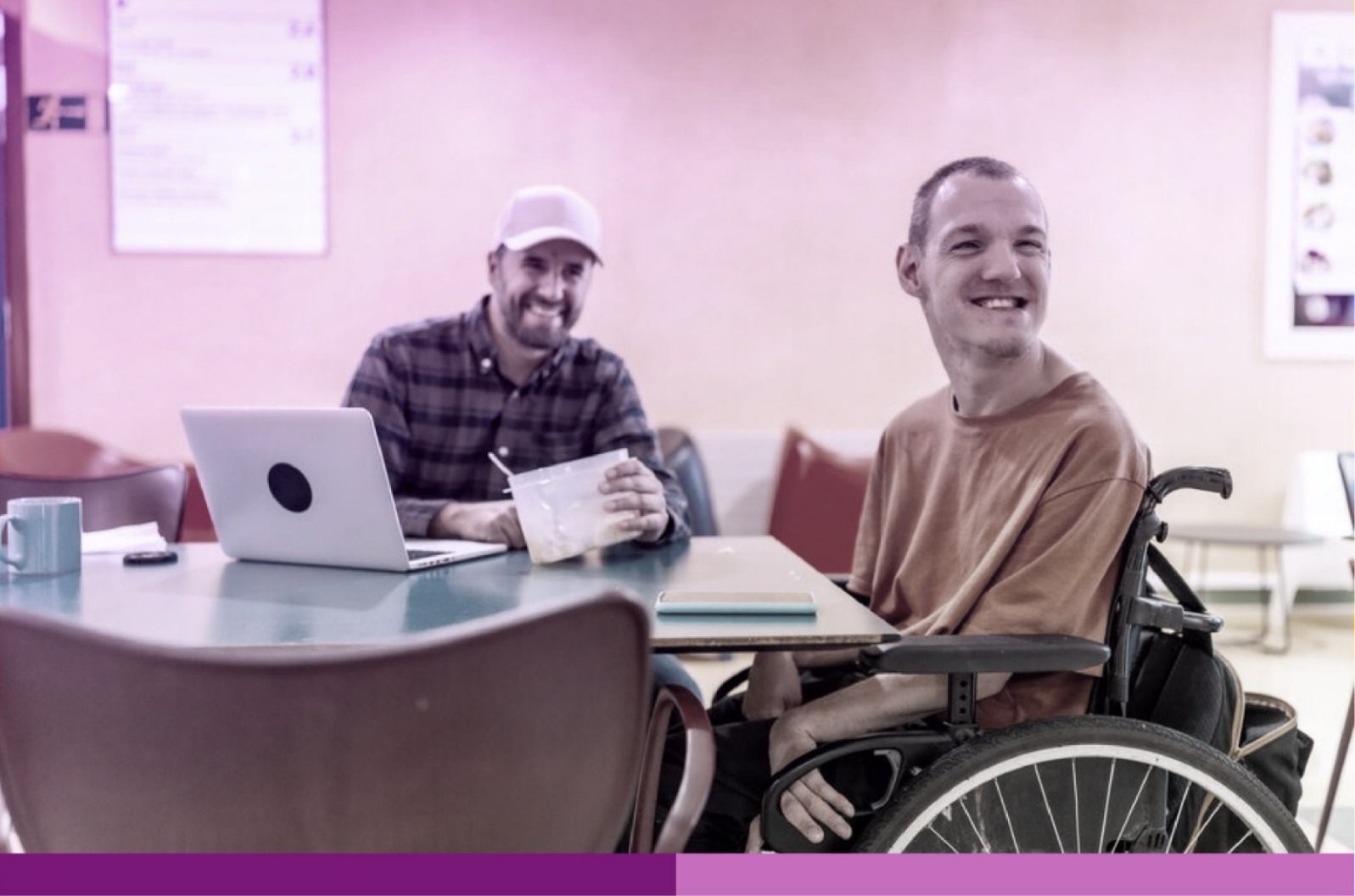 Joven en silla de ruedas junto a otro en una oficina.