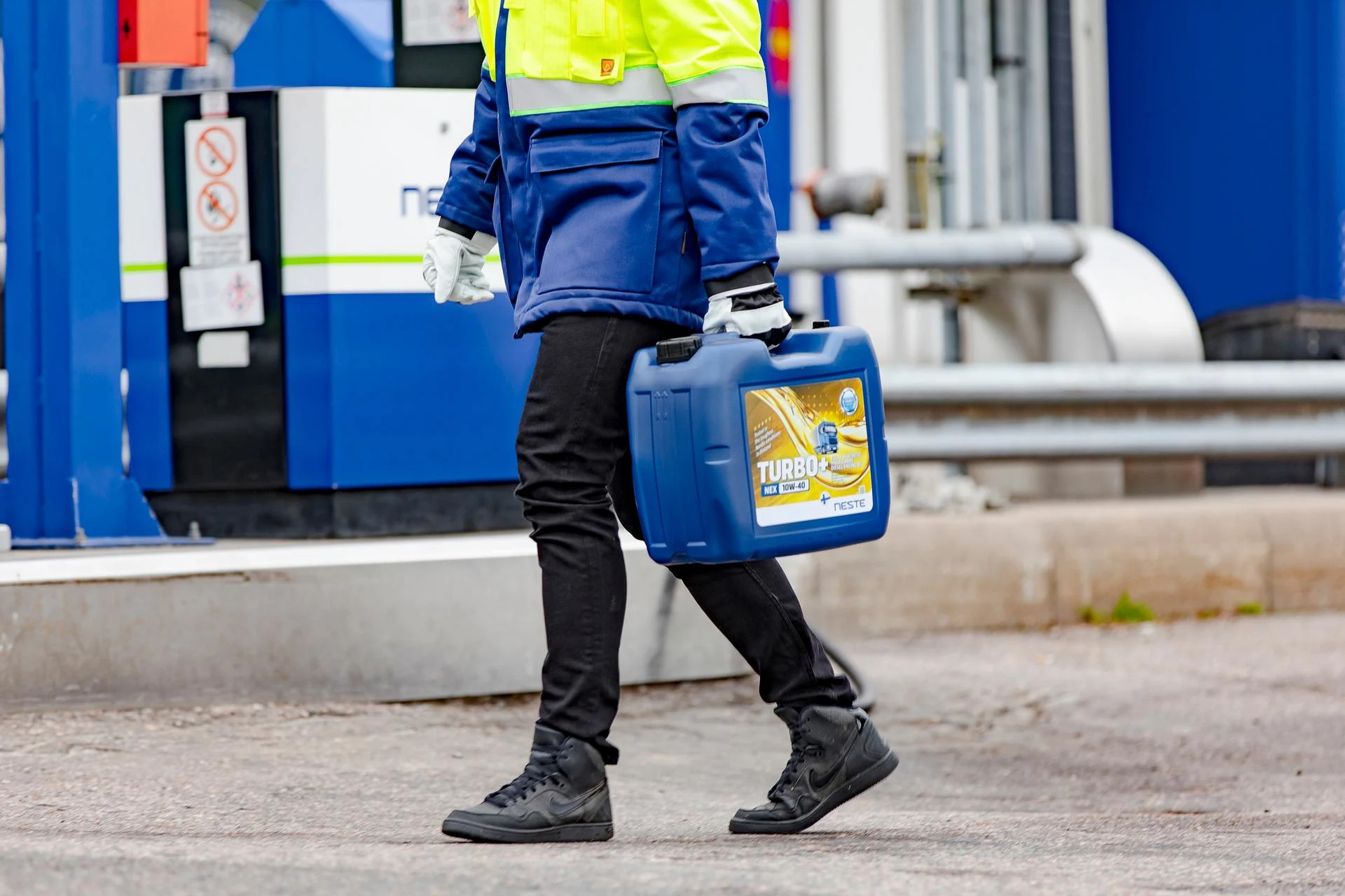 Työntekijä kantaa moottoriöljyä