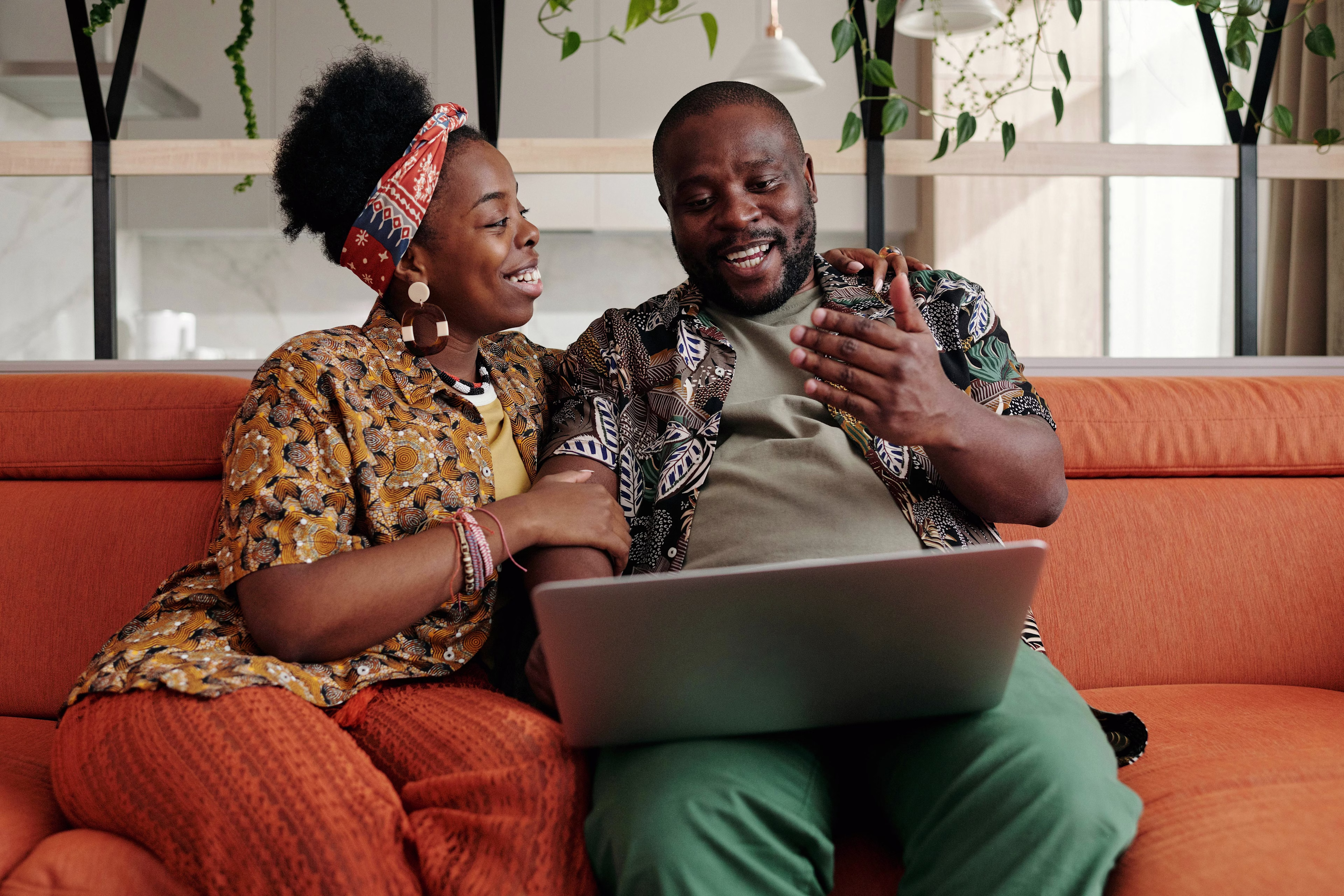 People Using Laptop on Couch in Indoor Setting - Stock image