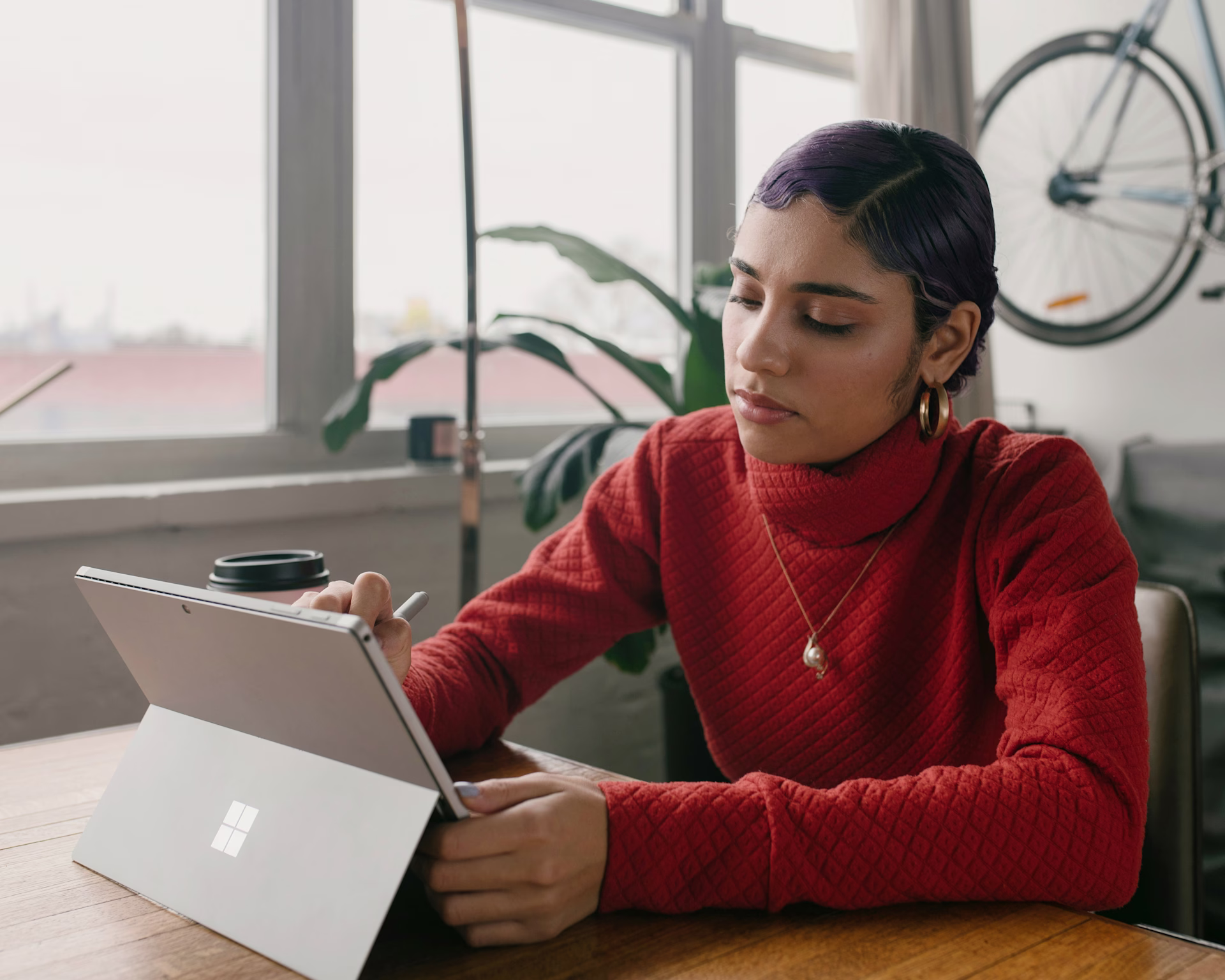 Woman Using Tablet with Laptop in Indoor Office Setting - Stock image