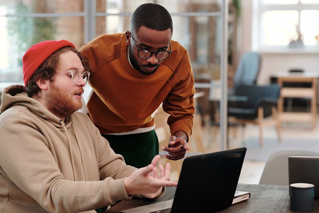 Indoor Office Scene with Two People Working on Laptop - stock image