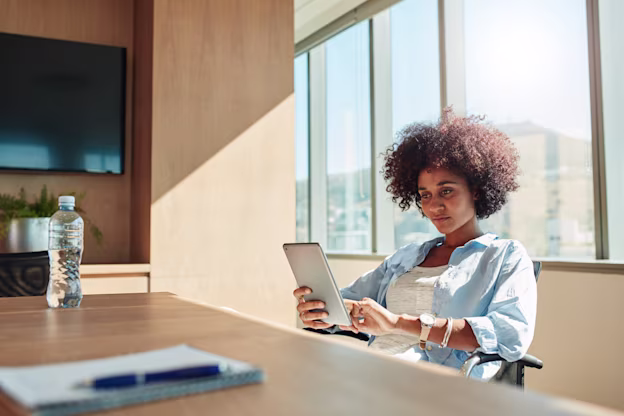[visual] woman sitting in office and using digital tablet