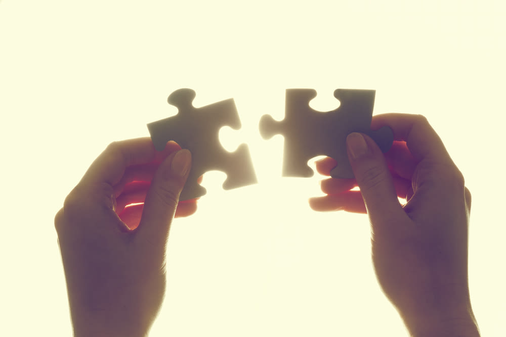 Joining two pieces of jigsaw puzzle. Backlit