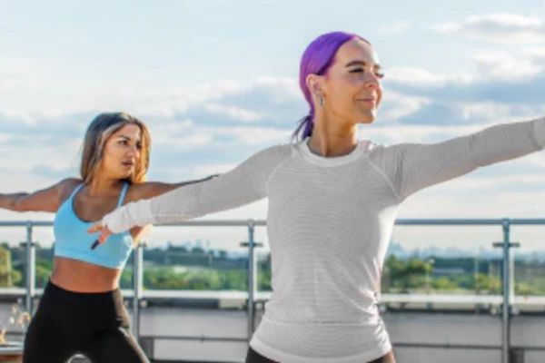 Deux femmes faisant du yoga sur un toit