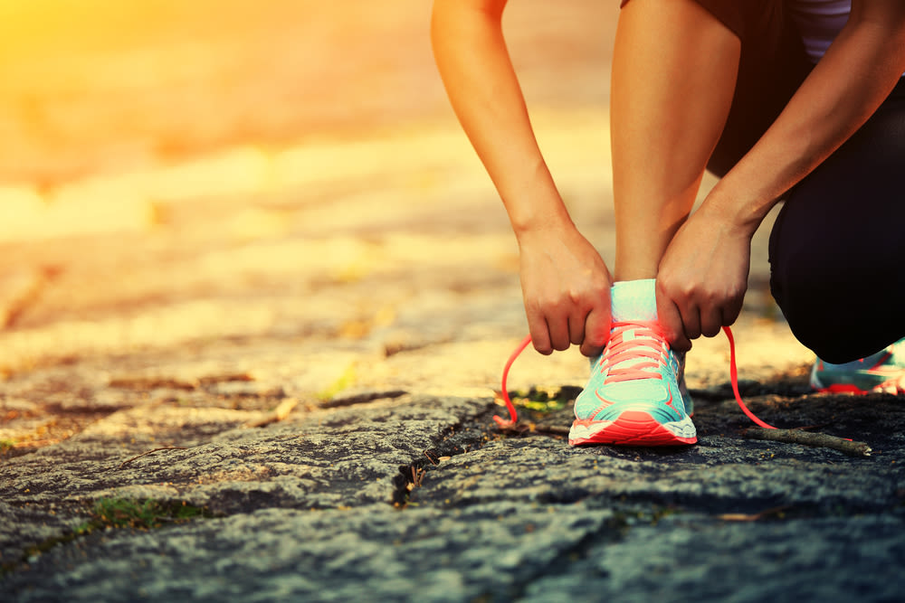 young woman runner tying shoelaces