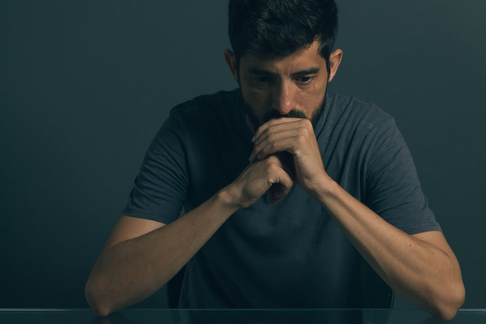 sad man sitting in dark room