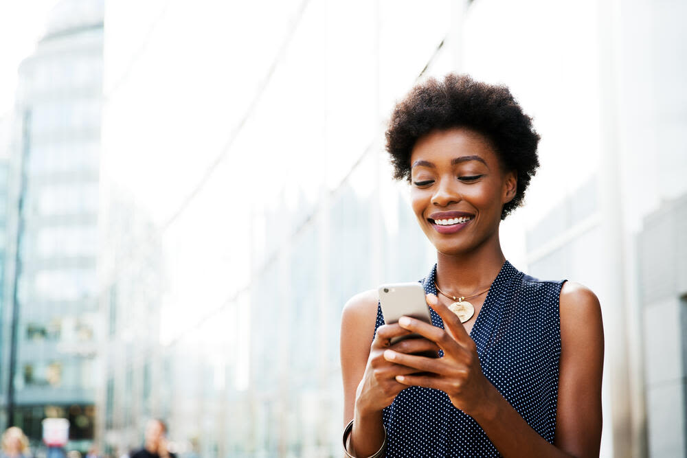 Woman using mobile next to buildings