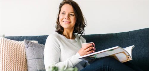 Woman sitting on a sofa with a mug