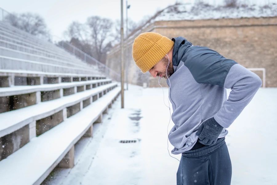 Homme s'apprêtant à faire du jogging dans la neige.
