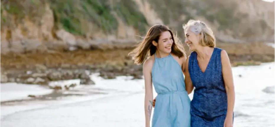 Mor og datter i godt humør på stranden