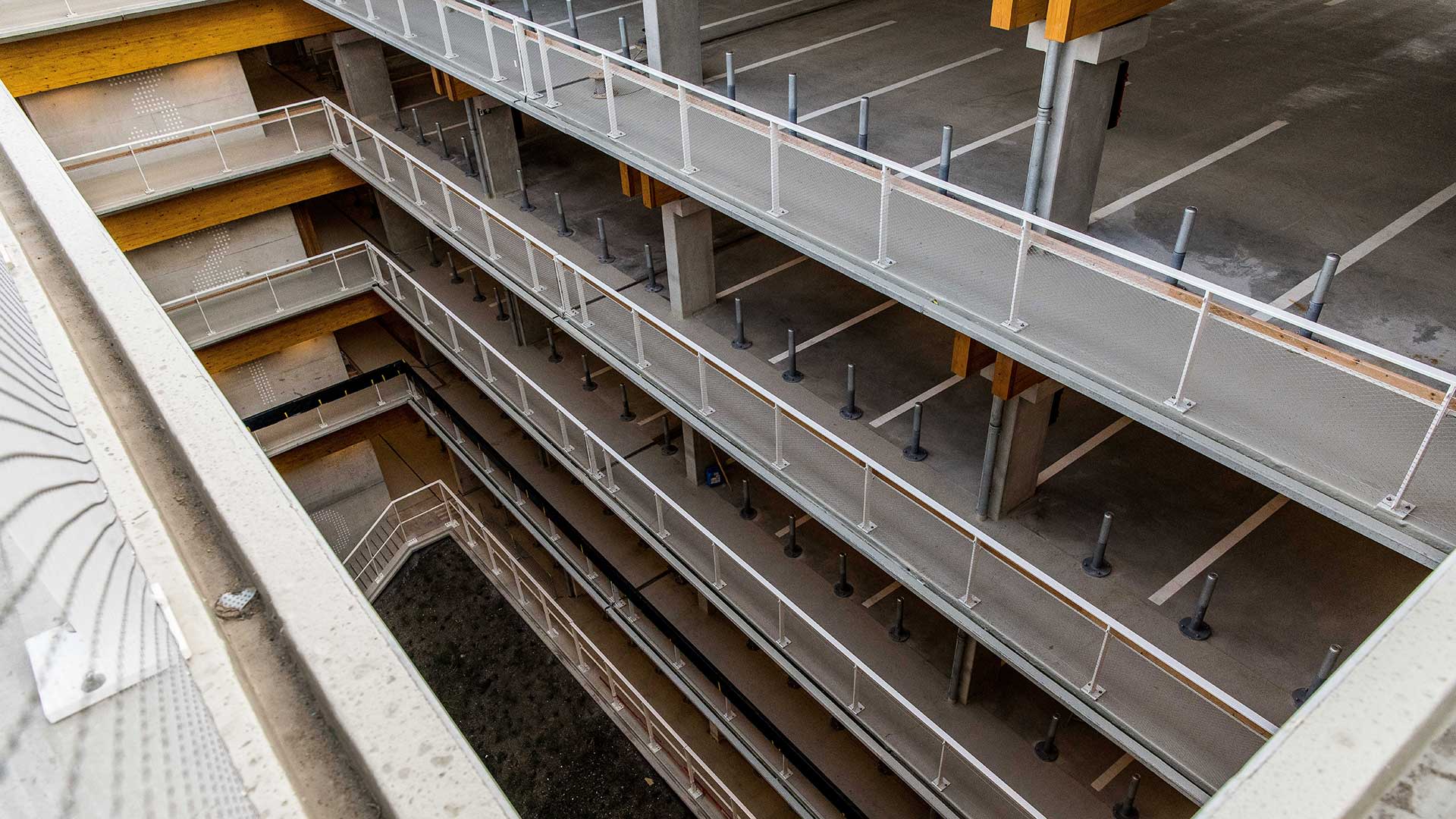 Een grote parkeergarage, bekeken vanop de bovenste verdieping.