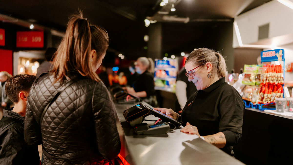 Bezoekers bestellen drankjes aan een bar in Vorst Nationaal, met keuze uit alcoholische en niet-alcoholische dranken.