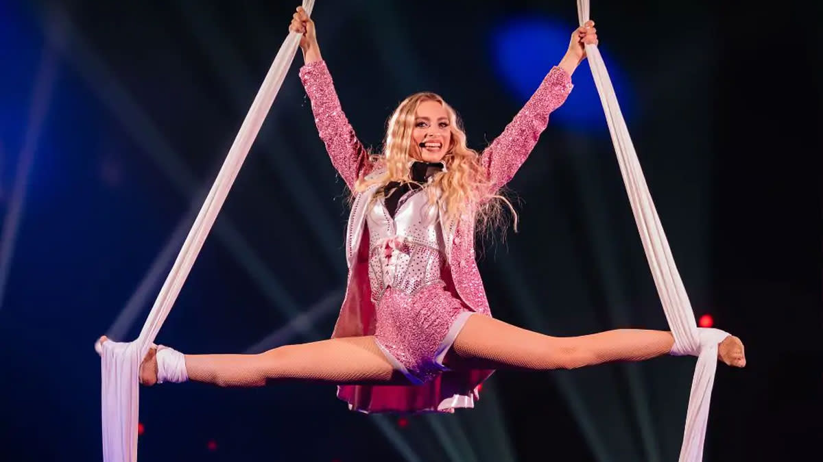 Camille tijdens een circusstunt waarbij ze in de lucht hangt aan twee doeken.