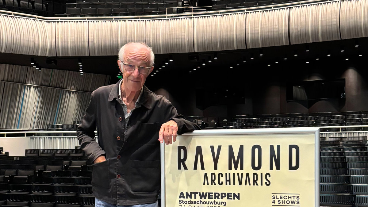 Raymond van het Groenewoud poseert bij zijn concertposter.
