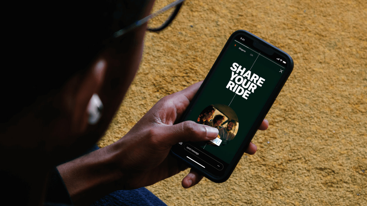 Een concertbezoeker houdt een smartphone in de hand en is op zoek naar een carpoolrit.
