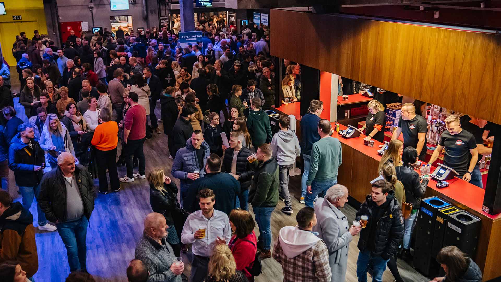 De foyer van Trixxo Theater Hasselt staat vol met mensen die genieten van een drankje.