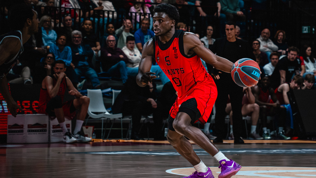 Een speler van Windrose Giants Antwerp in rode sportuitrusting zet de aanval in tijdens een wedstrijd in de Lotto Arena.