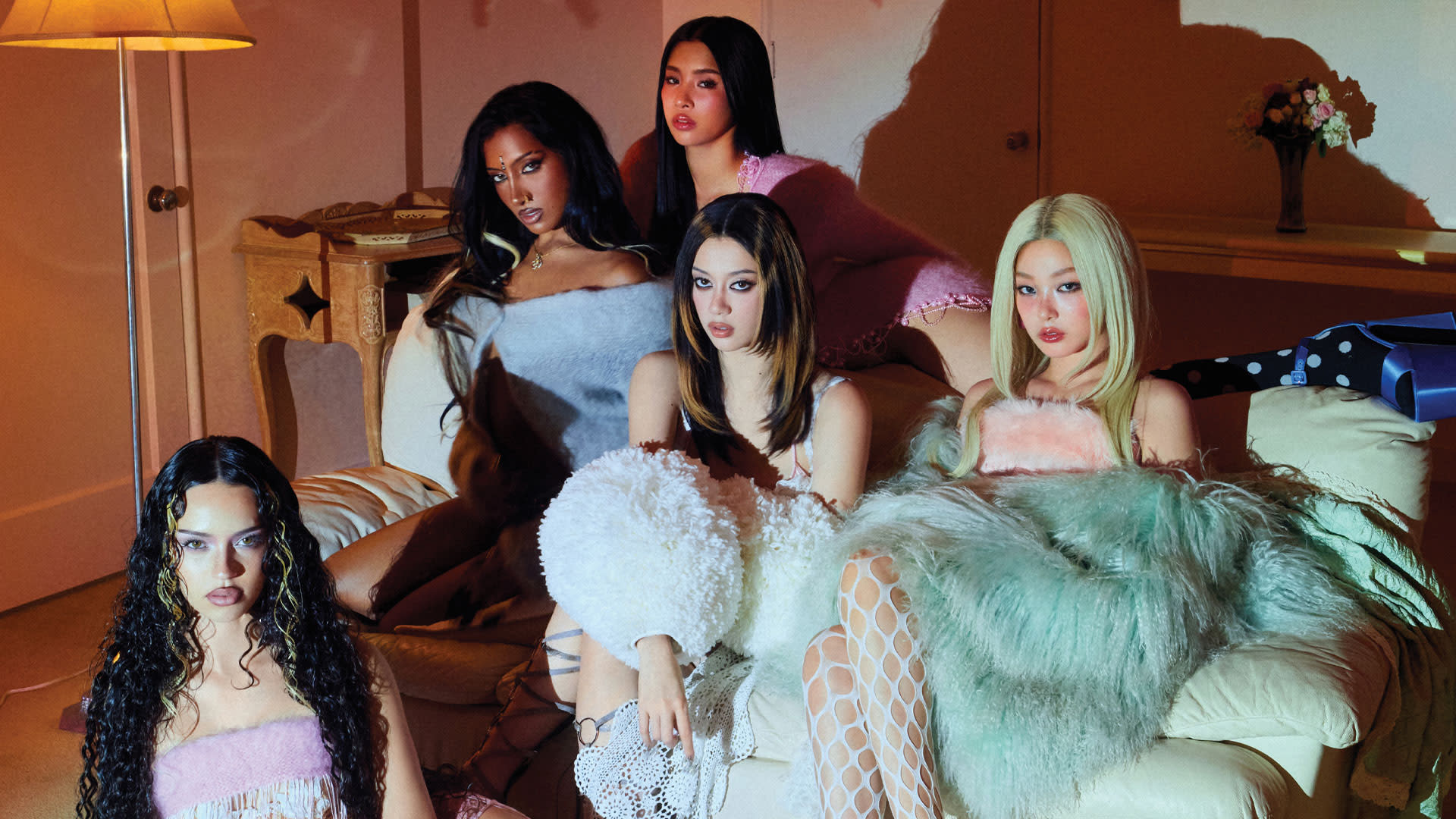 KATSEYE posing together in a stylish interior to promote the WILD HEARTS documentary ahead of their concert at the AFAS Dome.