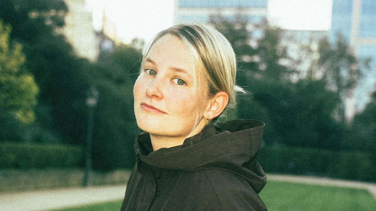 She The DJ bevindt zich in een park en kijkt recht in de cameralens.