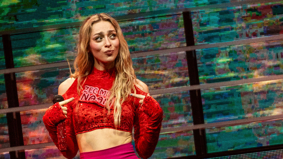 Camille in een rode outfit op het podium tijdens een van haar vorige shows in de Lotto Arena.