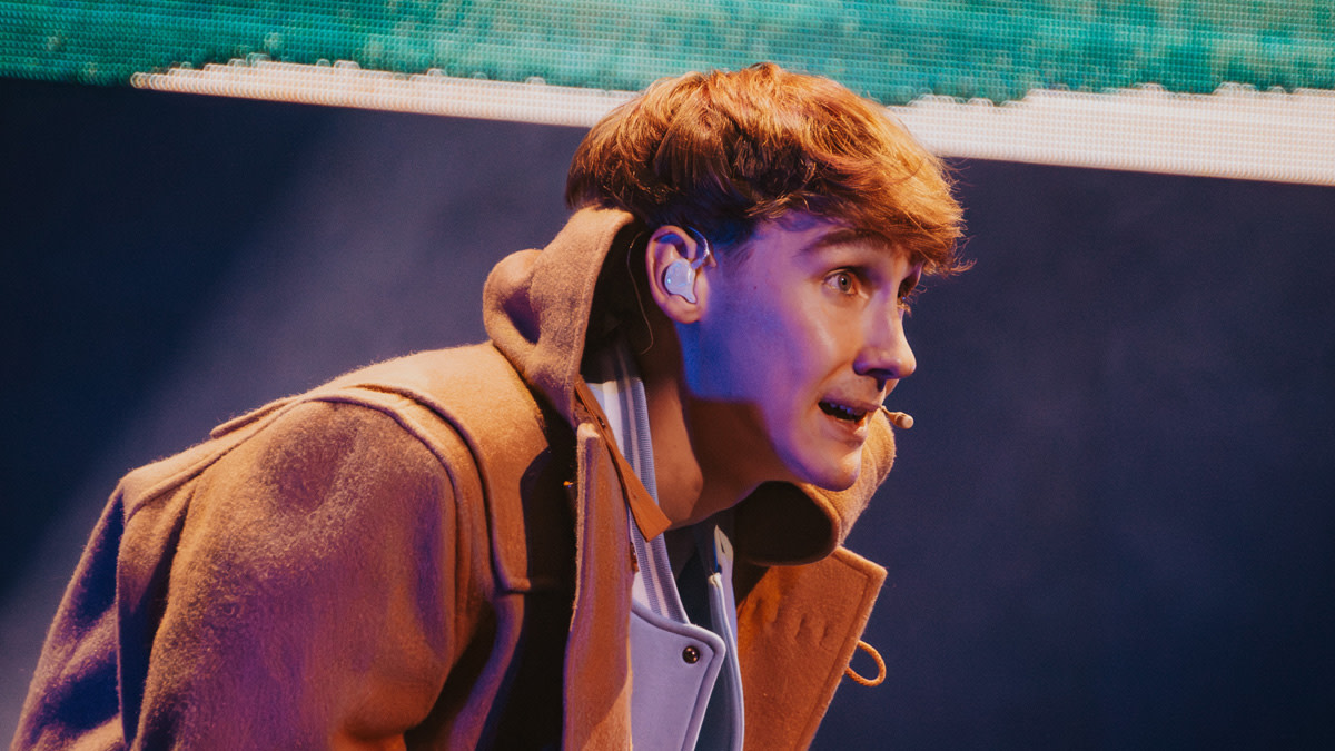 Job Dutchtuber met een warme jas aan op het podium in Stadsschouwburg Antwerpen.